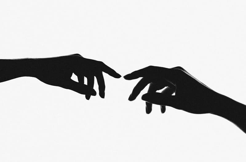 Two hands reaching towards each other